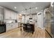 Kitchen features white cabinets, an island with seating, and stainless steel appliances at 1351 Ashbury Park Dr, Hoschton, GA 30548