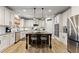 Kitchen features white cabinets, an island with seating, and stainless steel appliances at 1351 Ashbury Park Dr, Hoschton, GA 30548