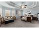 The primary bedroom with tray ceiling, multiple windows, a sofa and an ensuite bathroom at 1351 Ashbury Park Dr, Hoschton, GA 30548