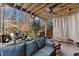 Relax on the covered deck with a fan, outdoor seating, swing, and scenic views of the wooded backyard at 1351 Ashbury Park Dr, Hoschton, GA 30548