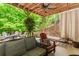 Comfortable outdoor patio with an outdoor sofa, swing, brick accents, and natural shade at 1351 Ashbury Park Dr, Hoschton, GA 30548