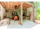 This covered patio has an outdoor fan, wooden beams, comfortable seating, and an outdoor swing at 1351 Ashbury Park Dr, Hoschton, GA 30548