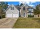 Charming two-story home featuring a two-car garage, stone accents, and manicured front lawn at 6031 Autumn Green Dr, Fairburn, GA 30213