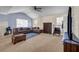 Comfortable living room with an L-shaped couch, a large window, and neutral carpet at 6031 Autumn Green Dr, Fairburn, GA 30213