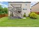 Grassy backyard featuring a deck, stairs, a pergola, and a fenced boundary for privacy at 4316 Woodland Bank Blvd, Buford, GA 30518