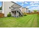 Spacious backyard featuring lush green grass, mature trees, and a wooden deck with pergola at 4316 Woodland Bank Blvd, Buford, GA 30518