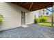 Basement exterior view showcasing a door, light gray siding, and gravel landscaping at 4316 Woodland Bank Blvd, Buford, GA 30518