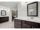 Bathroom with dark wood cabinets, double sinks and a view into the adjacent glass enclosed shower at 4316 Woodland Bank Blvd, Buford, GA 30518