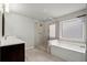 Bathroom featuring glass enclosed shower and soaking tub under a window for natural light at 4316 Woodland Bank Blvd, Buford, GA 30518