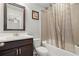 Bathroom features a dark wood vanity with white countertop, framed mirror, and shower with decorative curtain at 4316 Woodland Bank Blvd, Buford, GA 30518
