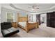 Main bedroom features tray ceilings, a wooden bed frame, and a barn-style sliding door at 4316 Woodland Bank Blvd, Buford, GA 30518