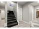 A staircase with carpet, and white risers, leads to a lower level; white chair in hallway at 4316 Woodland Bank Blvd, Buford, GA 30518