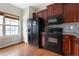 Kitchen featuring dark wood cabinets, granite countertops, and black appliances at 700 Celeste Sw Ln, Atlanta, GA 30331