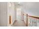 Bright hallway with wood railing and neutral carpeting leading to various rooms in the upper level of the home at 101 Hardwood Ln, Canton, GA 30115
