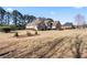 Beautiful stone exterior with a well-maintained lawn and mature trees on a sunny day at 2304 New Haven Pl, Conyers, GA 30094