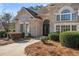 Close up of brick home featuring decorative entryway with black wrought iron doors and manicured landscaping at 2304 New Haven Pl, Conyers, GA 30094