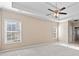 Bright primary bedroom with ceiling fan, tray ceilings, and large windows for natural light at 2304 New Haven Pl, Conyers, GA 30094