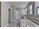 Well-lit bathroom with neutral walls, tile floors, soaking tub, and separate vanities at 4217 Heisenberg Ln, Suwanee, GA 30024