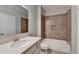 Well-lit bathroom with tile surround shower-tub and single sink vanity at 4217 Heisenberg Ln, Suwanee, GA 30024