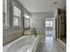 Neutral bathroom featuring a soaking tub, double windows, vanity and walk-in shower at 4217 Heisenberg Ln, Suwanee, GA 30024