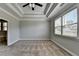 Neutral bedroom with trey ceiling, ceiling fan, plush carpet, and large windows for lots of natural light at 4217 Heisenberg Ln, Suwanee, GA 30024