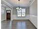 Dining area featuring a chandelier, wainscoting, and elegant hardwood flooring at 4217 Heisenberg Ln, Suwanee, GA 30024