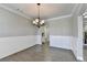 Well-lit dining room featuring classic wainscoting and hardwood flooring at 4217 Heisenberg Ln, Suwanee, GA 30024