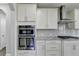 Kitchen features stainless steel double ovens and granite countertops at 4217 Heisenberg Ln, Suwanee, GA 30024