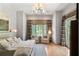 Spacious bedroom with a king bed, sitting area, and a window dressed with patterned curtains at 4520 Garmon Nw Rd, Atlanta, GA 30327