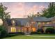 Stunning brick home showcasing manicured lawn, mature landscaping, and a welcoming entrance at dusk at 4520 Garmon Nw Rd, Atlanta, GA 30327