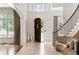 Bright foyer with travertine flooring, curved staircase, and open doorway at 4520 Garmon Nw Rd, Atlanta, GA 30327