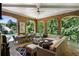 Covered outdoor living space with comfortable seating, dining area, and brick archways overlooking lush greenery at 4520 Garmon Nw Rd, Atlanta, GA 30327
