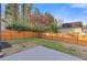 Fenced backyard with small tree, grass, and a concrete patio at 1074 Wenham Ln, Lawrenceville, GA 30044