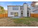 Back of house with a fenced-in backyard and a stone fireplace chimney at 1074 Wenham Ln, Lawrenceville, GA 30044