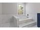 Bright bathroom features a soaking tub and a window with view of trees at 1074 Wenham Ln, Lawrenceville, GA 30044