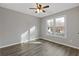 A bedroom with wood-look floors, a ceiling fan, and a window at 1074 Wenham Ln, Lawrenceville, GA 30044