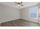 Comfortable bedroom with hardwood floors, ceiling fan, and a large window at 1074 Wenham Ln, Lawrenceville, GA 30044