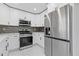 Modern kitchen featuring white cabinets, stainless steel appliances, and a tile backsplash at 1074 Wenham Ln, Lawrenceville, GA 30044