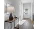 Bright hallway featuring wood floors and an accent table with a lamp as well as neutral paint and a white front door at 167 Belldown Ct, Mcdonough, GA 30253