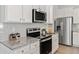 Kitchen featuring stainless steel appliances, granite counters, white cabinets, and stylish backsplash at 167 Belldown Ct, Mcdonough, GA 30253