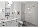 Bright bathroom featuring a white vanity, a large mirror, and a glass-enclosed shower with unique stone flooring at 3630 Peachtree Ne Rd # 3302, Atlanta, GA 30326
