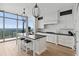 Modern white kitchen with marble backsplash, large island with bar seating, and a stunning city view at 3630 Peachtree Ne Rd # 3302, Atlanta, GA 30326