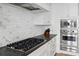 Close-up of the gourmet kitchen featuring a gas cooktop, stainless steel appliances, and a tile backsplash at 3630 Peachtree Ne Rd # 3302, Atlanta, GA 30326