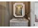 Stylish powder room features patterned wallpaper, marble countertop, and decorative mirror at 3630 Peachtree Ne Rd # 3302, Atlanta, GA 30326