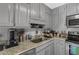 Granite countertops complement gray cabinets in this kitchen with stainless steel appliances at 820 Hounds Ridge Ct, Lawrenceville, GA 30043