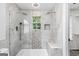 Bright bathroom with marble tile, walk-in shower with rainfall showerhead and window at 862 Gaston Sw St, Atlanta, GA 30310