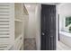 Bright walk-in closet leads to bathroom with tub, shelves, and storage at 862 Gaston Sw St, Atlanta, GA 30310