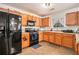 Kitchen features wood cabinets, neutral countertops, black appliances and tile floors at 345 Timberlake Ter, Covington, GA 30016