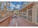 Spacious wooden deck adjacent to the screened porch with a picnic table and wooded views at 3916 Loch Highland Ne Pass, Roswell, GA 30075