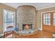 Unique stone fireplace with wood floors, a chair near a sunny window, and french doors at 3916 Loch Highland Ne Pass, Roswell, GA 30075